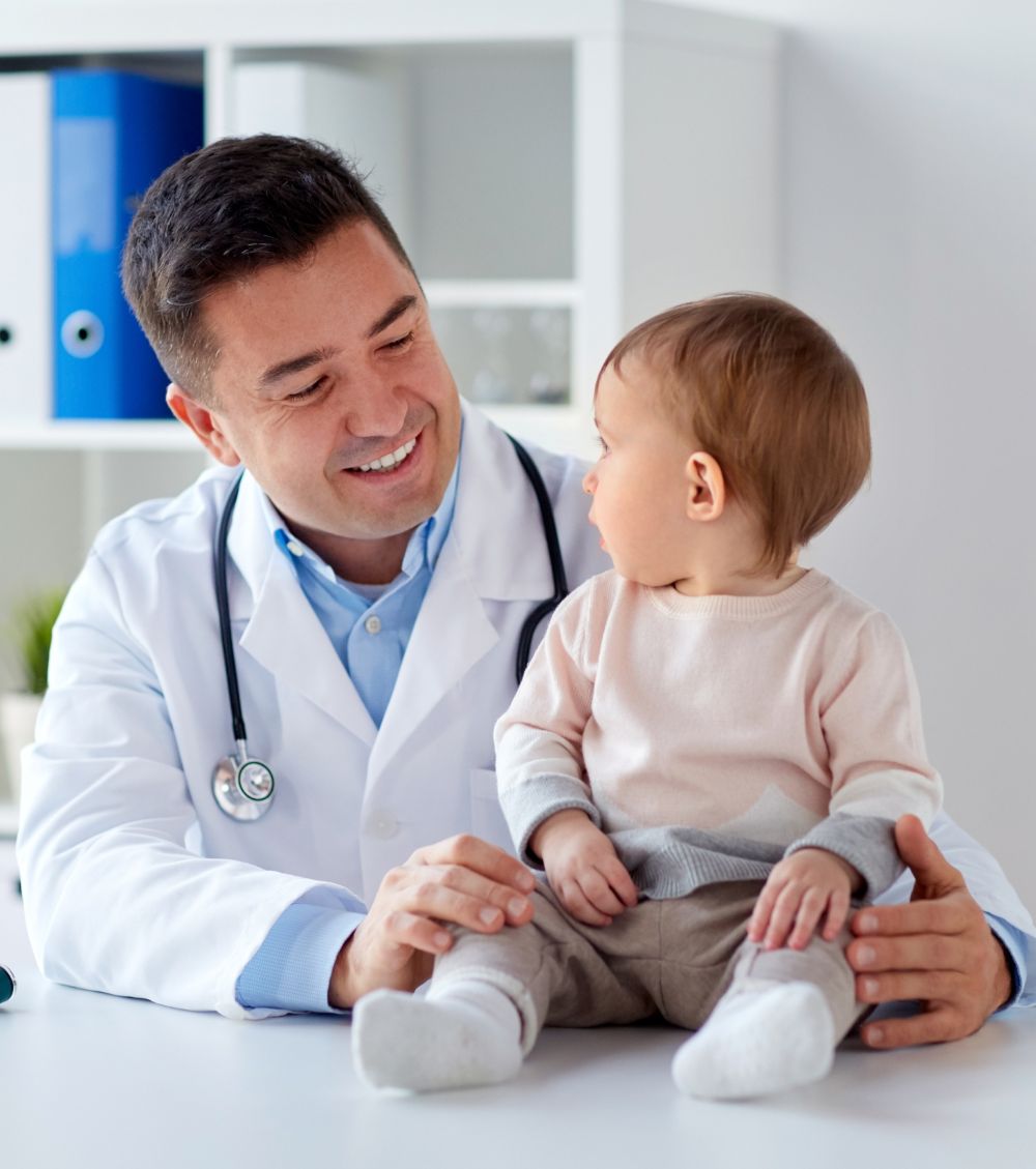 happy-doctor-or-pediatrician-with-baby-at-clinic-PXZU778-1-1.jpg